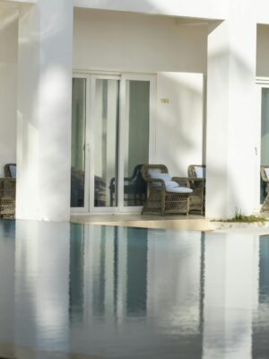 Minimalistic hotel poolside setup with elegant lounge chairs and modern architecture.
